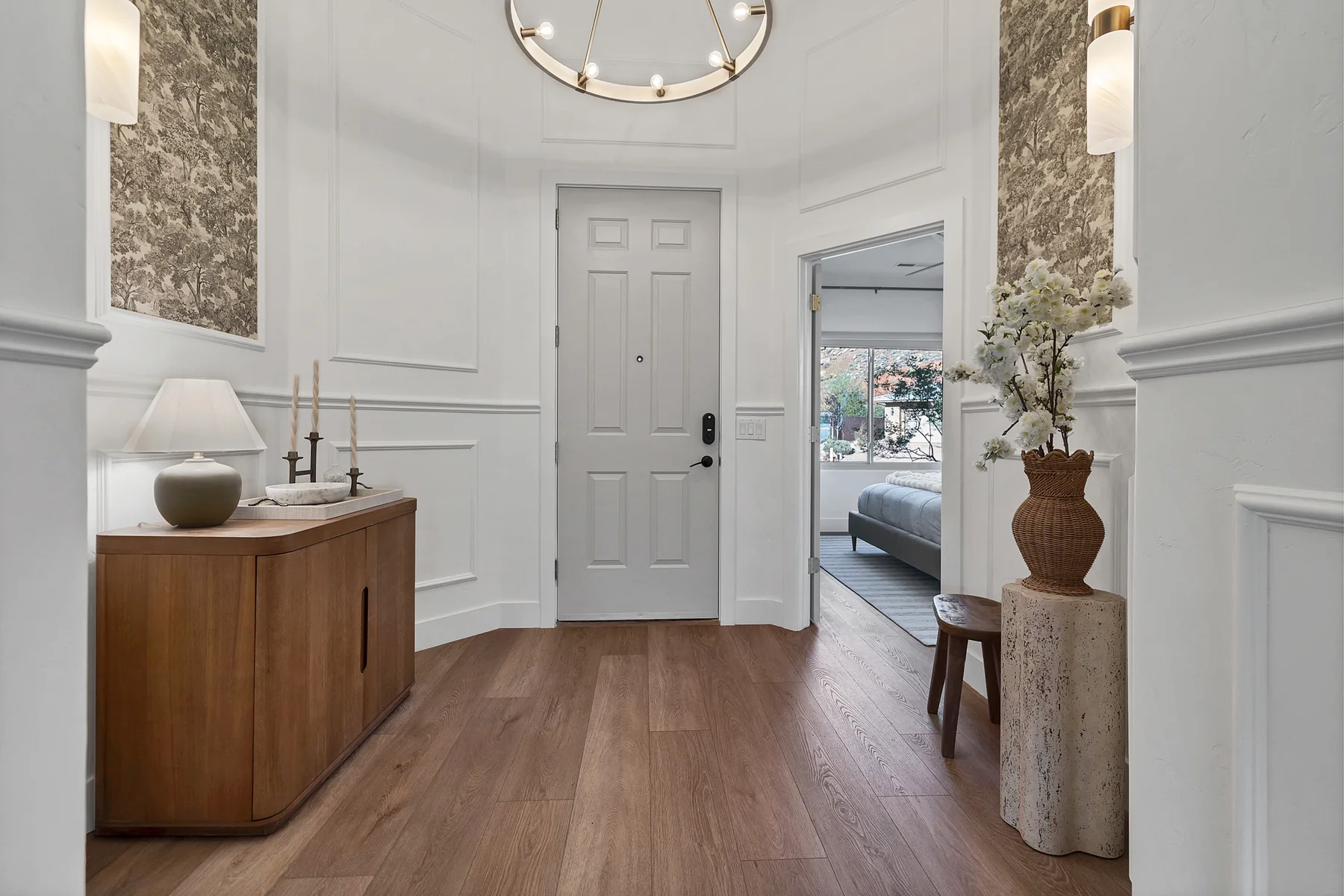 Detailed front entry with custom molding and warm wood furniture