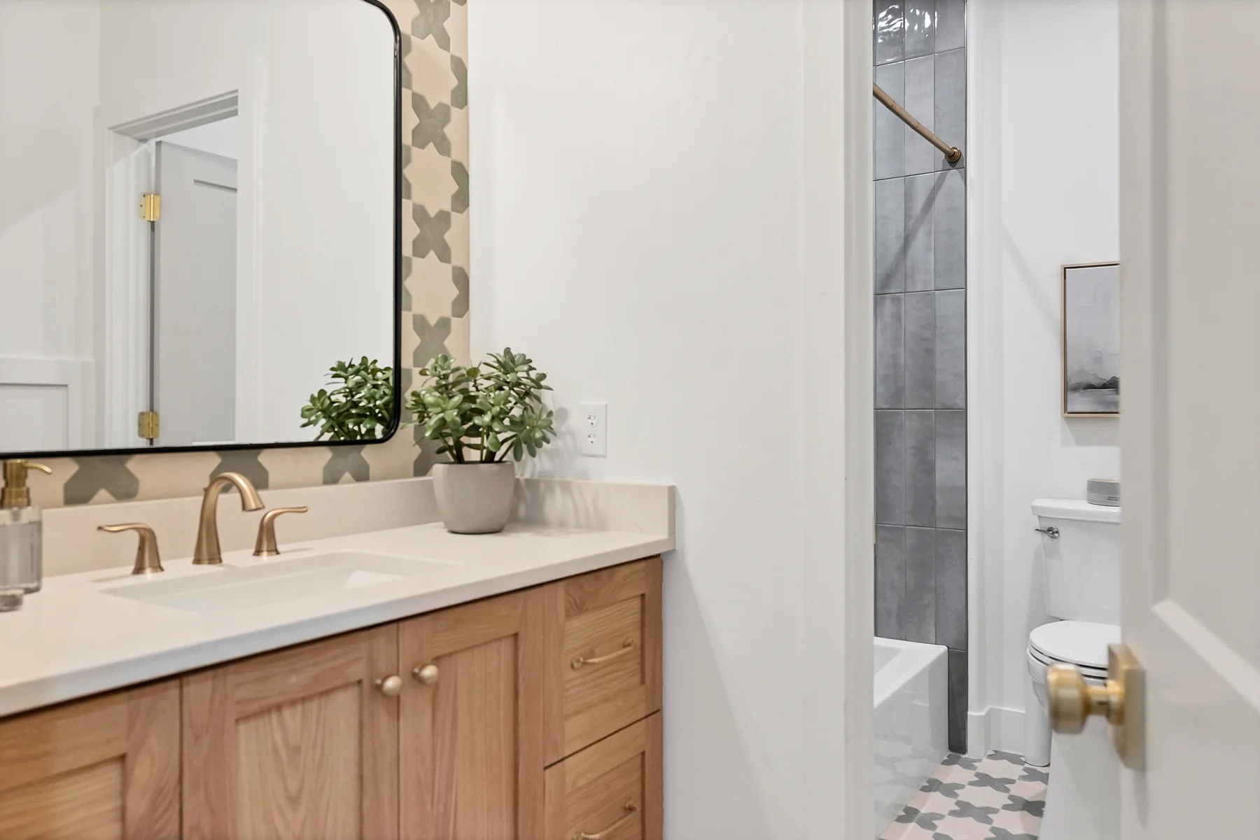 Guest bathroom with warm oak vanity and patterned tile