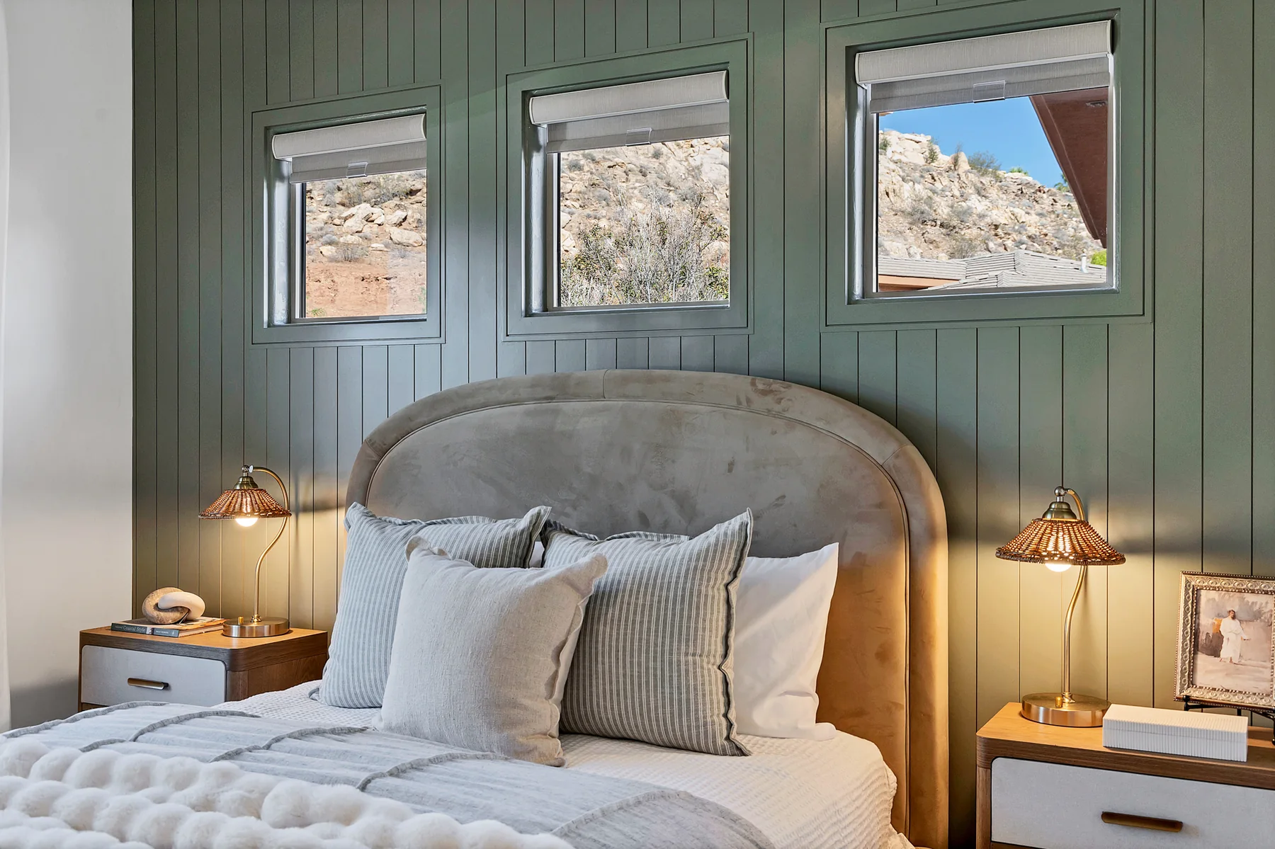 Guest bedroom with deep green paneled wall