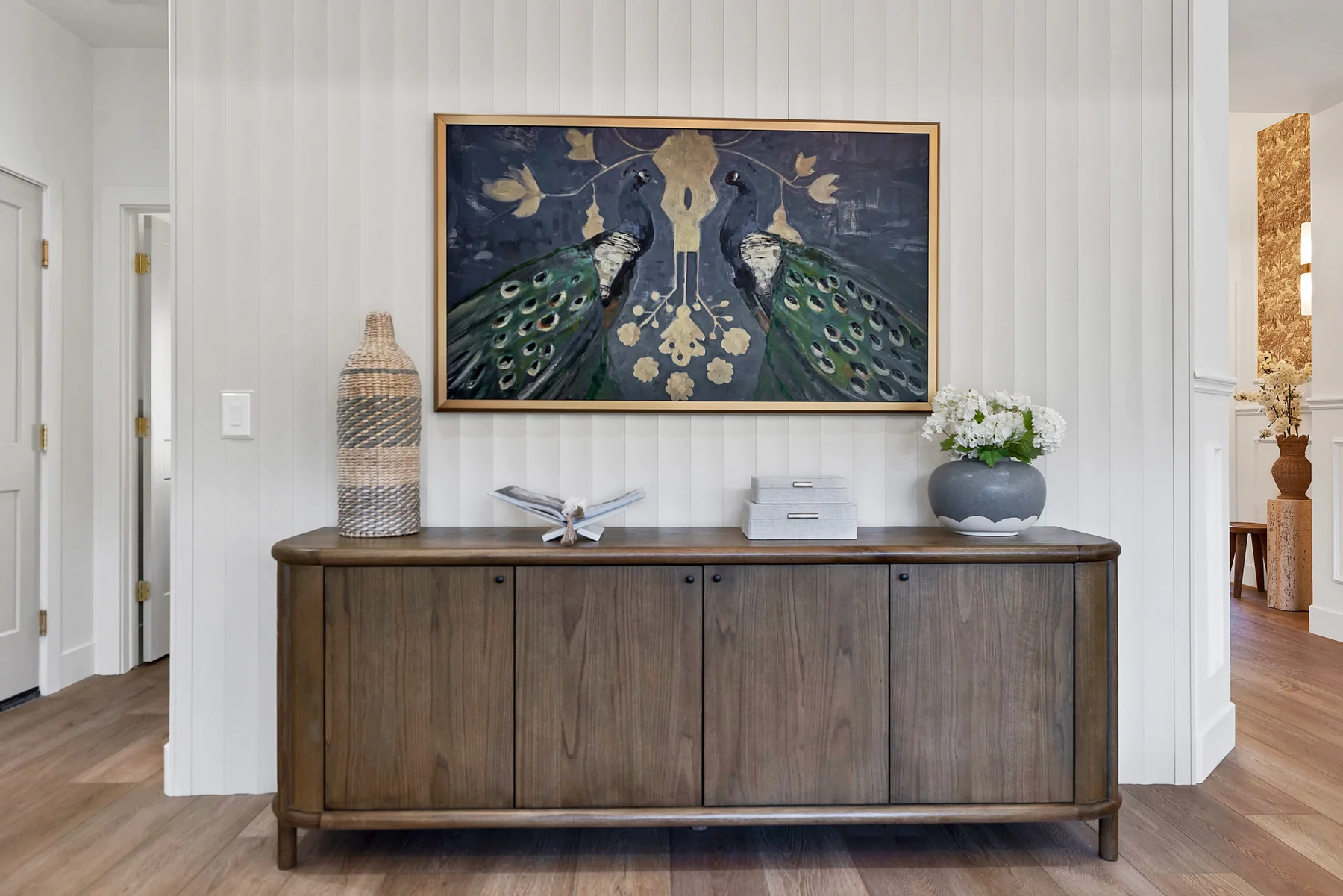 Custom wood cabinet beneath peacock artwork